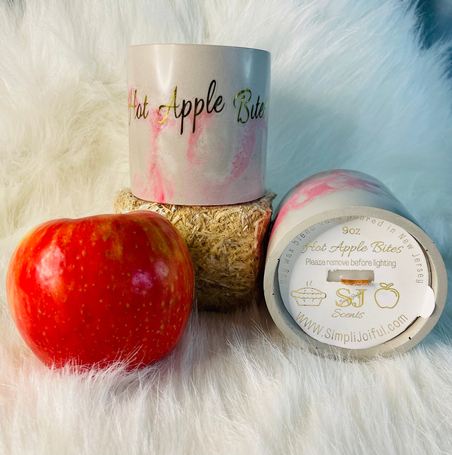 Hot Apple Bites candles on a hay bin along side an Apple 