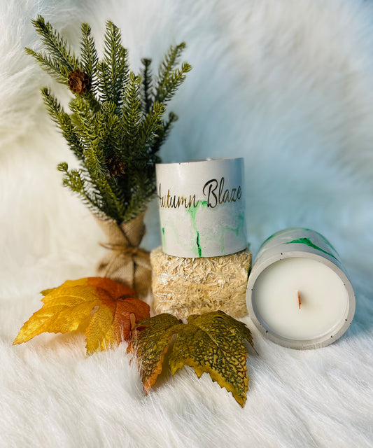 Autumn Blaze Candle on a hay bin surrounded by leaves and a tree